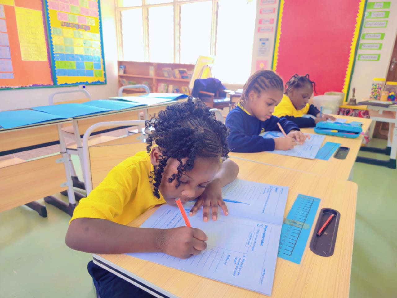 A primary pupil works carefully through her English exercise at a Cambridge Primary lesson.