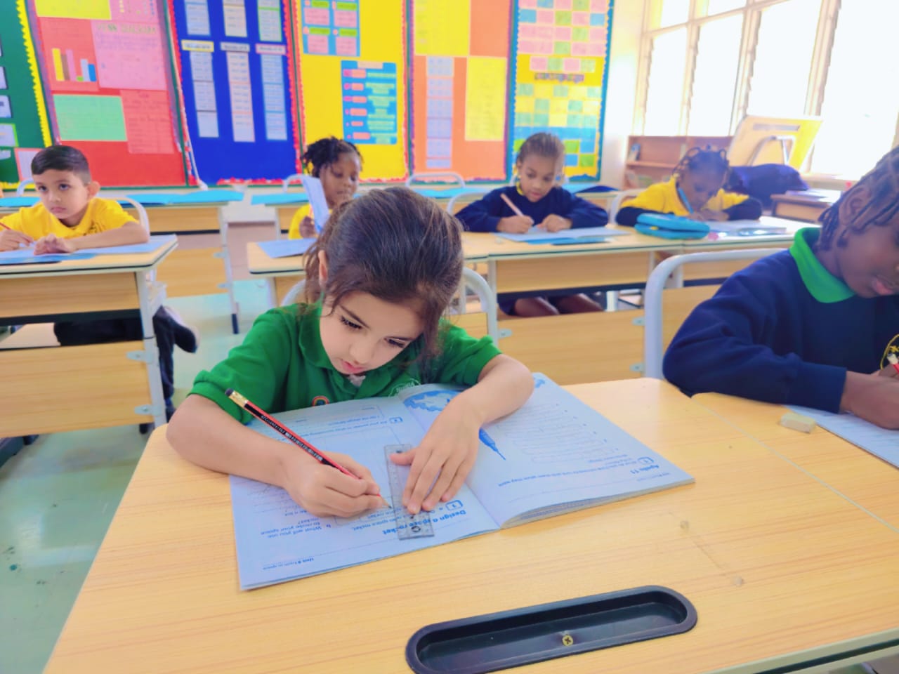 Guided writing practice at Simba, where classes stay small enough for every book to be seen.
