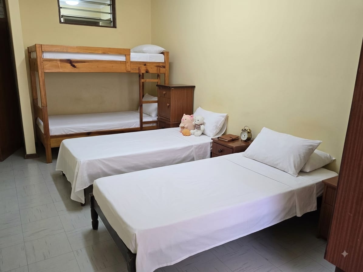 Boarding room with bunk and single beds neatly made