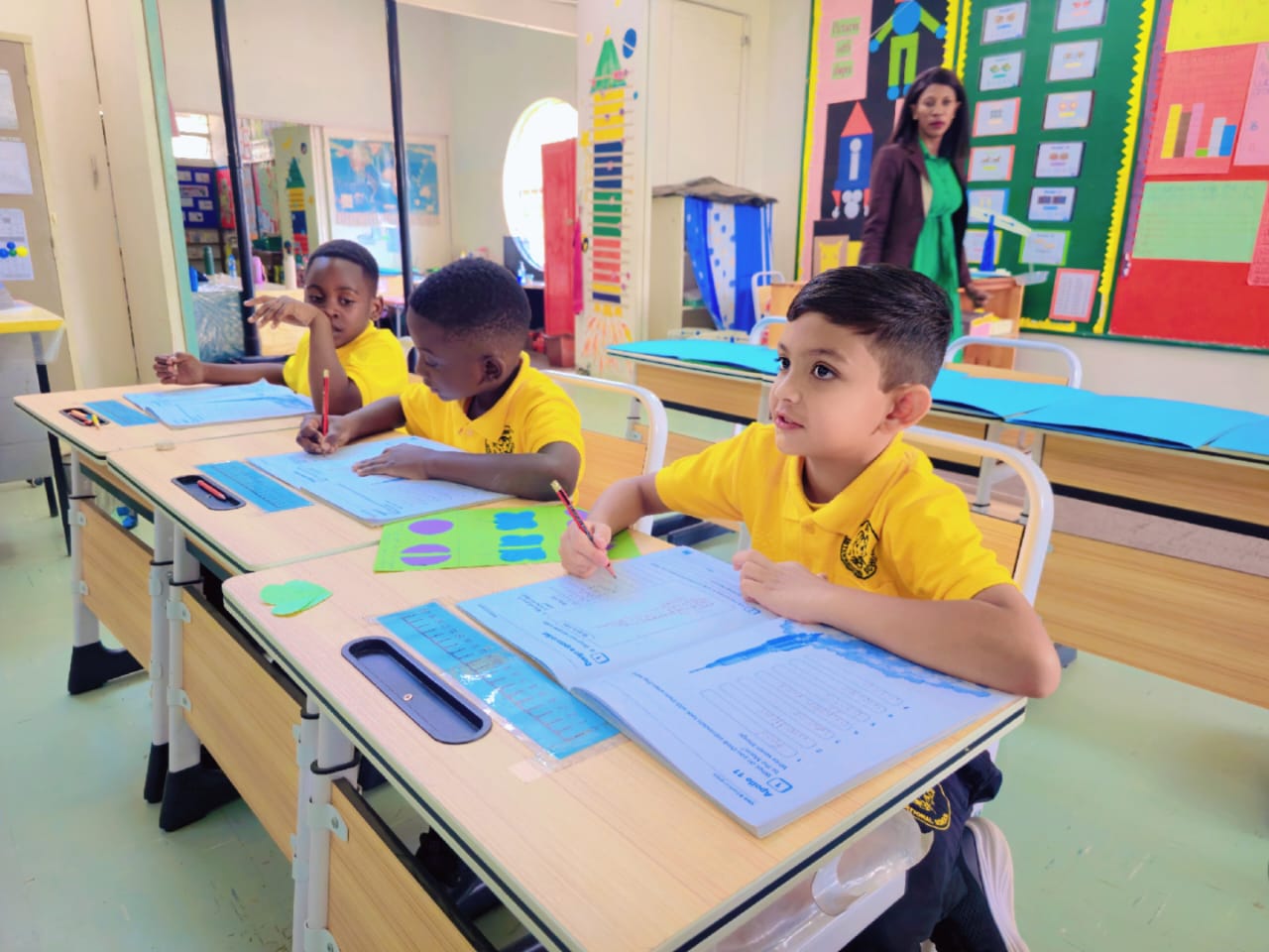 Two pupils compare answers on a worksheet — collaboration is built into every lesson.