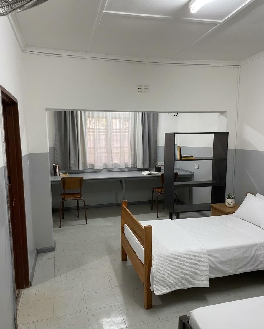 A boarder's room with study desk at Tau House